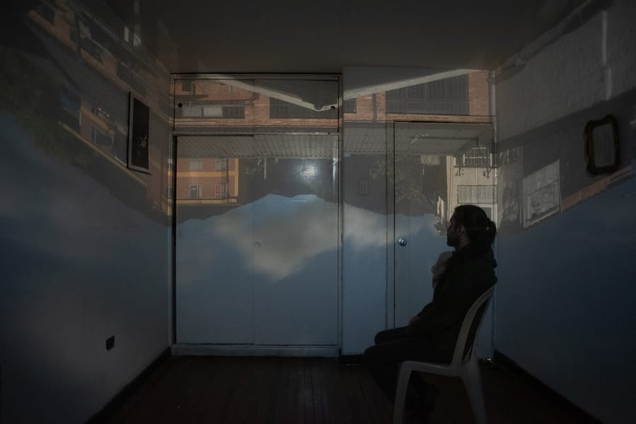 Hombre sentado en el interior de una cámara oscura